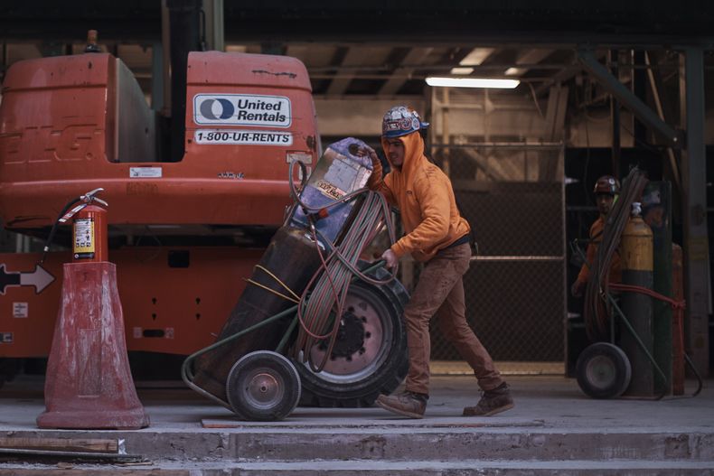 ARCHIVO - Trabajadores de construcción mueven equipos el 17 de enero de 2023, en Nueva York. (AP Foto/Andres Kudacki, Archivo)