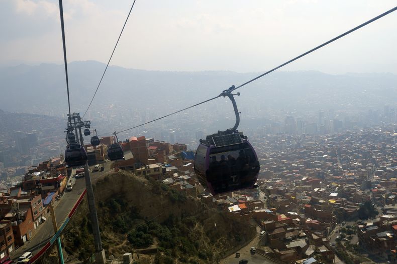 Los teleféricos se mueven en medio de una neblina de humo procedente de incendios forestales en La Paz, Bolivia, el lunes 20 de noviembre de 2023. (AP Foto/Juan Karita)