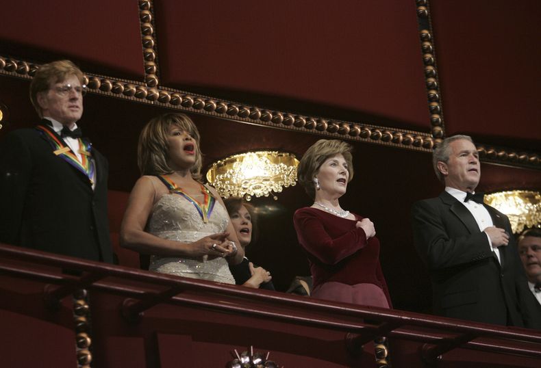 El presidente Bush, a la derecha, y la primera dama Laura Bush, segunda desde la derecha, junto al actor Robert Redford, a la izquierda, y la cantante Tina Turner en la Gala de Honor del Kennedy Center en Washington el 4 de diciembre de 2005. (Foto AP/Evan Vucci, archivo)