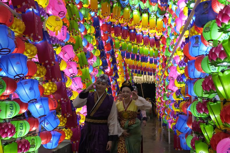 Una personas caminan junto a linternas durante el Festival de los Faroles de Loto, previo al cumpleaños de Buda en la Universidad Dongguk en Seúl, Corea del Sur, el sábado 11 de mayo de 2024. (Foto AP/Ahn Young-joon)