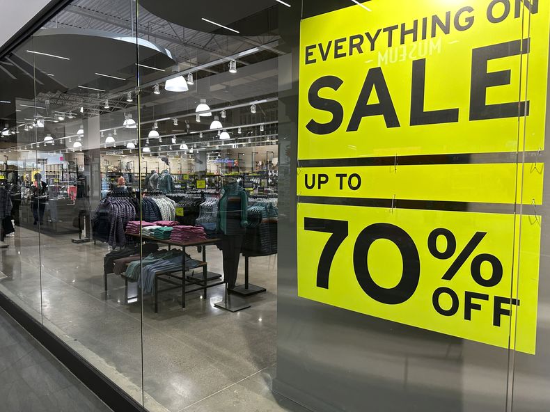 Un anuncio de ofertas cuelga en una ventana de una tienda de ropa el jueves 24 de agosto de 2023, en Lakewood, Colorado. (AP Foto/David Zalubowski)