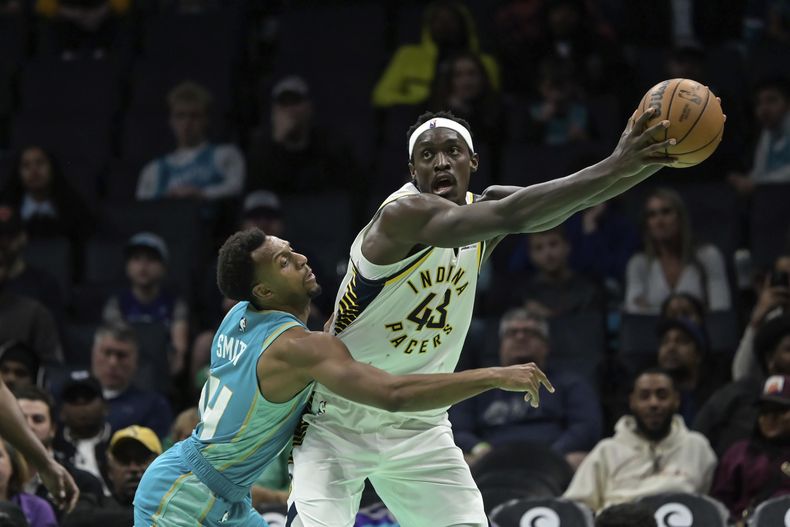 El base de los Hornets de Charlotte Ish Smith intenta robarle el balón al alero de los Pacers de Indiana Pascal Siakam en el encuentro de la NBA el domingo 4 de febrero del 2024. (AP Foto/Matt Kelley)