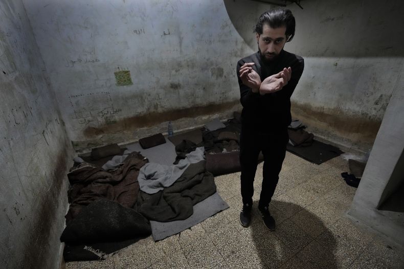 Abdullah Zahra muestra cómo fue torturado en una celda de la Sección 215, un centro de detención dirigido por la inteligencia militar durante el régimen de Bashar Assad, en Damasco, Siria, el martes 17 de diciembre de 2024. (AP foto/Hussein Malla)
