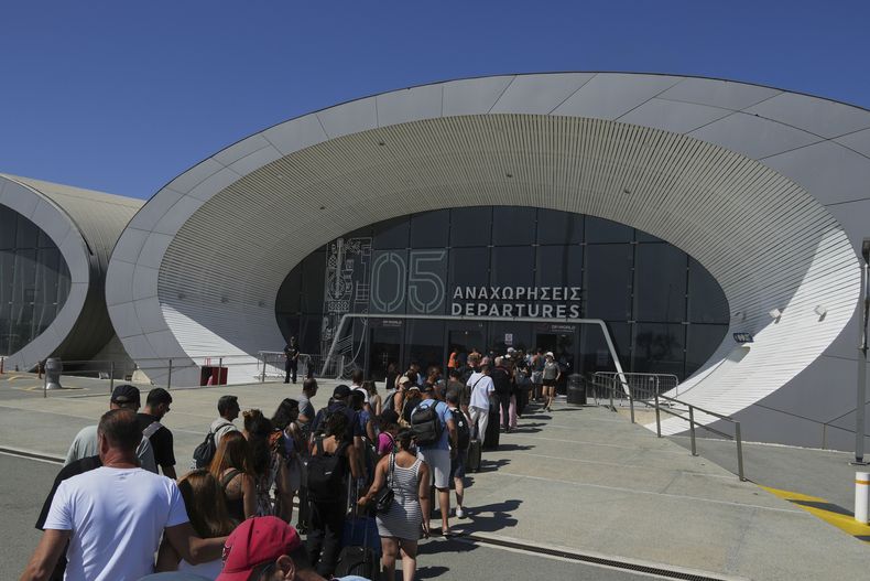 Israelíes hacen fila para entrar en la terminal de salidas del principal puerto de Chipre, en Limassol, donde embarcarán en el crucero israelí Crown Iris para regresar al país, el 19 de junio de 2025. (AP Foto/Petros Karadjias)