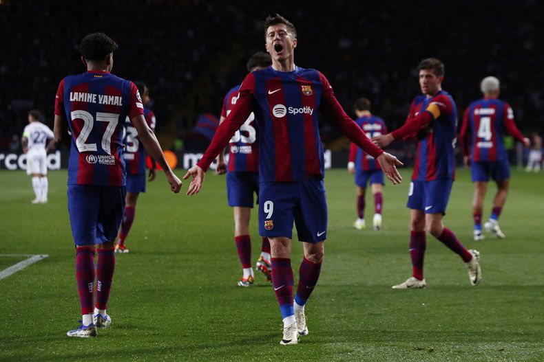 ARCHIVO . Robert Lewandowski, de Barcelona, celebra un gol de su equipo en partido de la Liga de Campeones. Barcelona FC se comprometió en 2018 a jugar un partido de La Liga de España en Miami, pero tuvo que retirar su compromiso por un principio deportivo de FIFA que indicaba que los partidos de liga deben disputarse en el terrotorio de su respectiva asociación mimbro. (AP Foto/Joan Monfort)