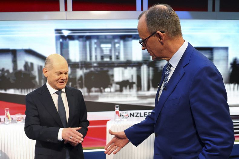 ARCHIVO - El canciller de Alemania, Olaf Scholz (izquierda), del partido Socialdemócrata, y Friedrich Merz (derecha), líder de la Unión Democristiana, se saludan en un estudio de televisión antes de un debate electoral, en Berlín, Alemania, el 19 de febrero de 2025. (Fabrizio Bensch/Pool Foto vía AP, archivo)