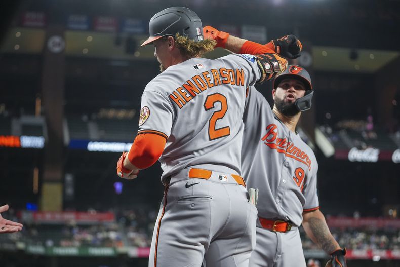 Gunnar Henderson (2), de los Orioles de Baltimore, es felicitado cerca del dugout por Gary Sánchez después de batear un jonrón de dos carreras contra los Rangers de Texas durante la 10ma entrada del juego de béisbol de Grandes Ligas el 30 de junio de 2025, en Arlington, Texas. (AP Foto/Julio Cortez)