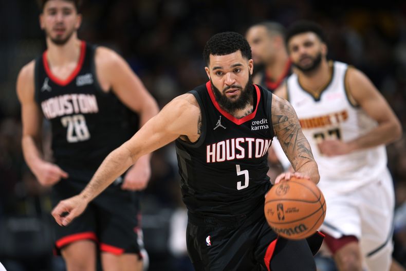 Fred VanVleet, al frente, de los Rockets de Houston, controla un balón suelto mientras que su compañero de equipo Alperen Sengun, izquierda, y Jamal Murray, de los Nuggets de Denver, lo sigue con la mirada durante la segunda mitad del juego de baloncesto de la NBA, el viernes 8 de diciembre de 2023, en Denver. (AP Foto/David Zalubowski)
