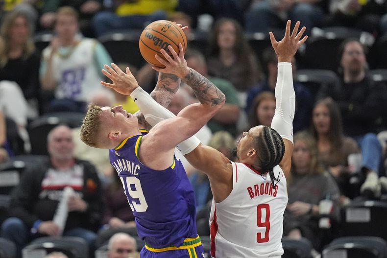Dillon Brooks, alero de los Rockets de Houston, comete una falta sobre Luka Samanic, del Jazz de Utah, el jueves 11 de abril de 2024 (AP Foto/Rick Bowmer)