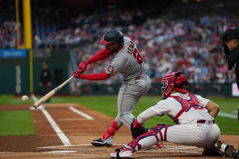 El dominicano José Tena, de los Nacionales de Washington, conecta un sencillo productor ante el lanzador de los Filis de Filadelfia, el mexicoamericano Taijuan Walker, durante la primera entrada de un juego de béisbol, el lunes 30 de marzo de 2026, en Filadelfia. (Foto AP/Matt Rourke)