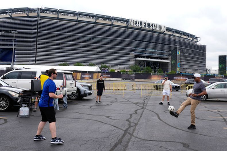 ARCHIVO - Foto del domingo 13 de julio del 2025, aficionados juegan con un balón afuera del Estadio Metlife antes de la final de la Copa Mundial de Clubes entre el Chelsea y Paris Saint-Germain. (AP Foto/Pamela Smith, Archivo)