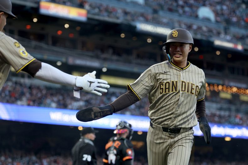 Sung-Mun Song, de los Padres de San Diego, recibe la felicitación del dominicano Manny Machado tras anotar ante los Gigantes de San Francisco, el martes 5 de mayo de 2026 (AP Foto/Jed Jacobsohn)