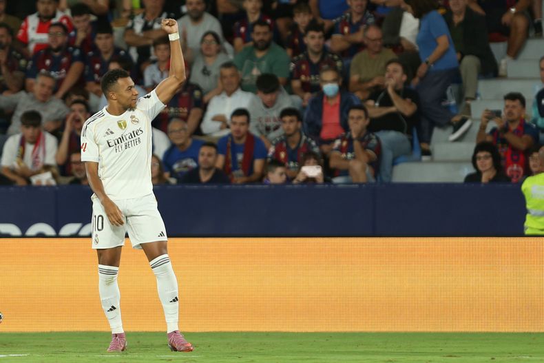 Kylian Mbappé (izquierda) celebra tras anotar el tercer gol del Real Madrid en la victoria 4-1 ante Levante en la Liga de España, el martes 23 de septiembre de 2025, en Valencia. (AP Foto/Alberto Saiz)