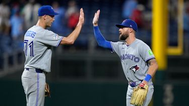 Tyler Rogers (izquierda), de los Azulejos de Toronto, festeja con Nathan Lukes, tras el duelo ante los Filis de Filadelfia, el sábado 8 de agosto de 2026 (AP Foto/Matt Slocum)