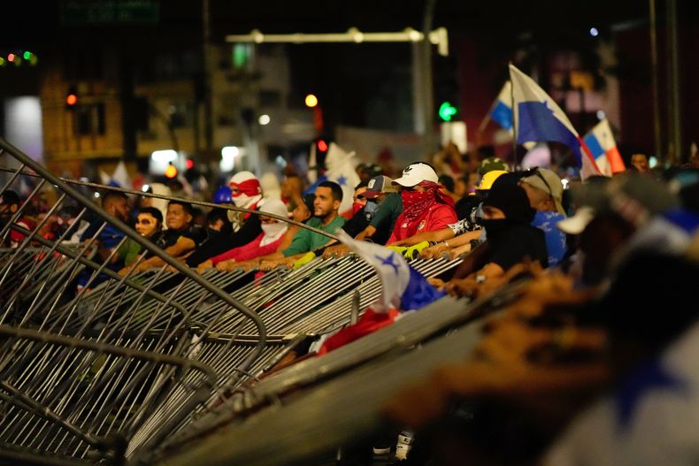 Manifestantes derriban una barricada policial durante una protesta contra un contrato minero recientemente aprobado entre el gobierno y la empresa minera canadiense First Quantum, en la ciudad de Panamá, el martes 31 de octubre de 2023. (AP Foto/Arnulfo Franco)