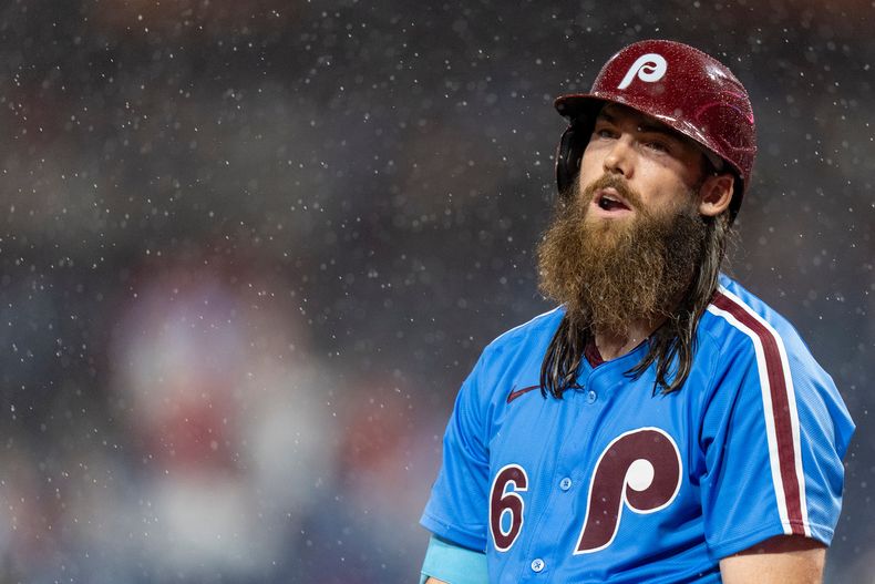 Brandon Marsh, de los Filis de Filadelfia, observa a las cuadrillas que colocan la lona sobre el terreno para protegerlo de la lluvia en el juego del jueves 25 de septiembre de 2025, ante los Marlins de Miami (AP Foto/Chris Szagola)