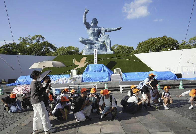 Visitantes en el Parque de la Paz se agachan tras una alerta de sismo en Nagasaki, en el oeste de Japón, el jueves 8 de agosto de 2024. (Kyodo News via AP)