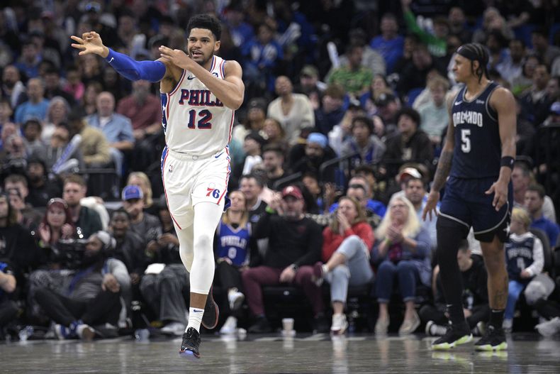Tobias Harris, alero de los 76ers de Filadelfia, celebra tras atinar un triple frente a Paolo Banchero, del Magic de Orlando, el miércoles 27 de diciembre de 2023 (AP Foto/Phelan M. Ebenhack)