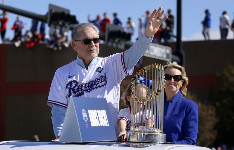 El mánager de los Rangers de Texas Bruce Bochy en el autobus en el desfile junto al trofeo de campeón de la Serie Mundial al lado de su esposa Kim Seib en Arlington, Texas el viernes 3 de noviembre del 2023. (Tom Fox/The Dallas Morning News via AP, Pool)
