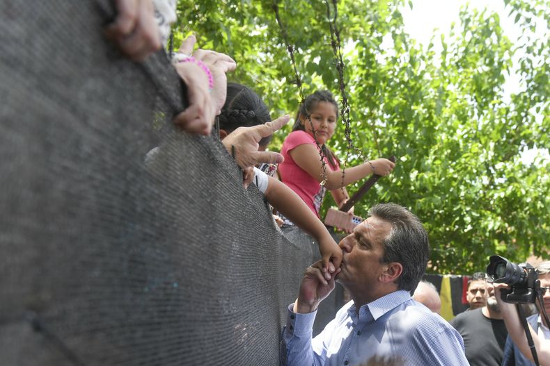 El ministro de Economía y aspirante presidencial Sergio Massa besa la mano de una niña después de votar en la segunda vuelta presidencial en Tigre, en las afueras de Buenos Aires, Argentina, el domingo 19 de noviembre de 2023. (Foto AP/Gustavo Garello)