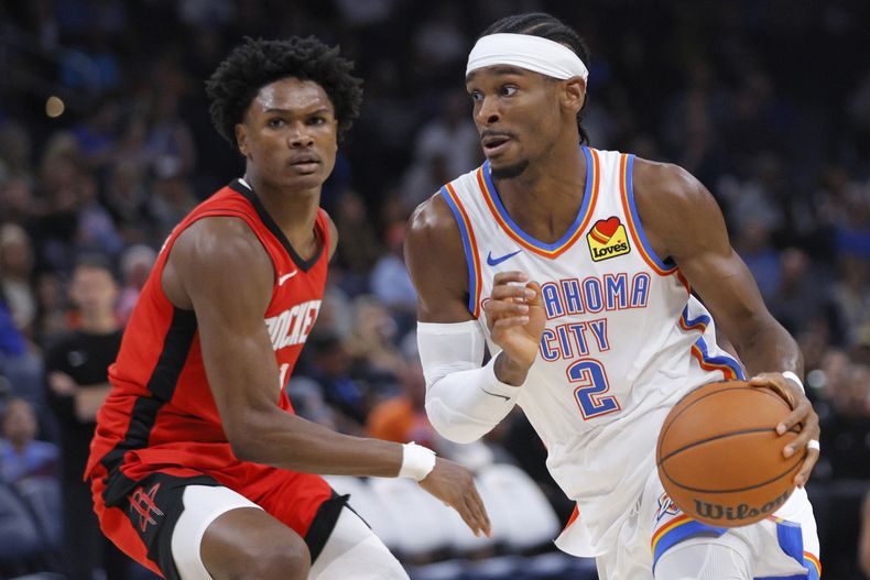 Shai Gilgeous-Alexander, del Thunder de Oklahoma City, avanza frente a Amen Thompson, de los Rockets de Houston, en el encuentro del miércoles 9 de octubre de 2024 (AP Foto/Nate Billings)