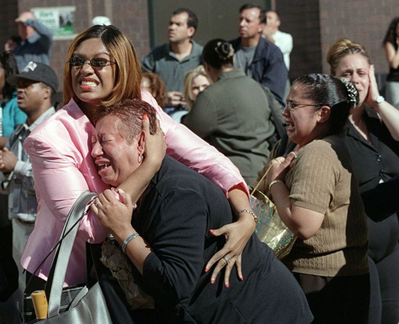 ARCHIVO - Dos mujeres se abrazan mientras observan el incendio del World Trade Center tras un ataque terrorista contra las Torres Gemelas, el 11 de septiembre de 2001, en Nueva York. (AP Foto/Ernesto Mora, archivo)
