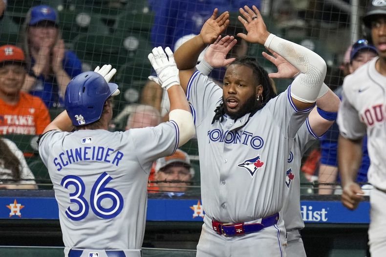 Davis Schneider, de los Azulejos de Toronto, festeja con su compañero Vladimir Guerrero tras conectar un jonrón decisivo ante los Astros de Houston, el martes 2 de abril de 2024 (AP Foto/Eric Christian Smith)