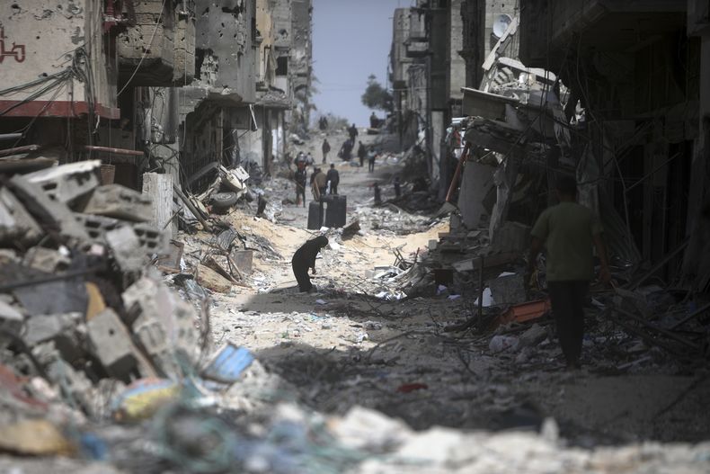 Palestinos visitan sus viviendas destruidas luego de la salida de las tropas israelíes de Jan Yunis, en la Franja de Gaza, el 6 de marzo de 2024. (AP Foto/Mohammed Dahman)