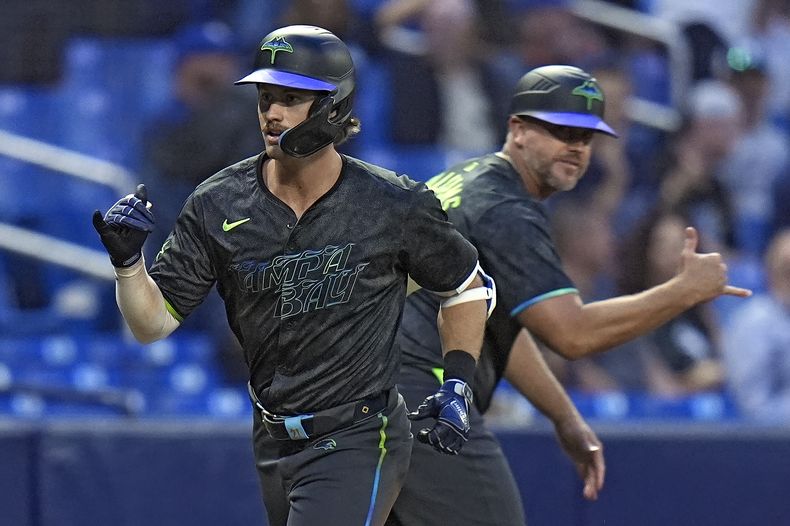 Jonny DeLuca, izquierda, de los Rays de Tampa Bay, celebra su jonrón de dos carreras contra el relevista de Medias Blancas de Chicago, Jared Shuster, con el coach de tercera Brady Williams durante la quinta entrada del juego de béisbol del lunes 6 de mayo de 2.24, en San Petersburgo, Florida. (AP Foto/Chris OMeara)