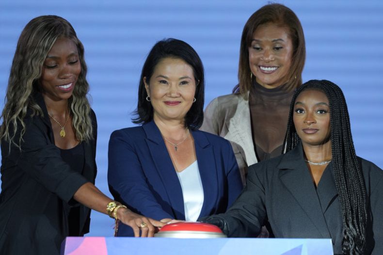 De izquierda a derecha, la deportista paralímpica colombiana Karen Palomeque, la presidenta peruana Keiko Fujimori y la gimnasta esrtadounidense Simone Biles oprimen el botón para activar la cuenta regresiva rumbo a los Juegos Panamericanos en Lima, el jueves 6 de agosto de 2026 (AP Foto/Guadalupe Pardo)