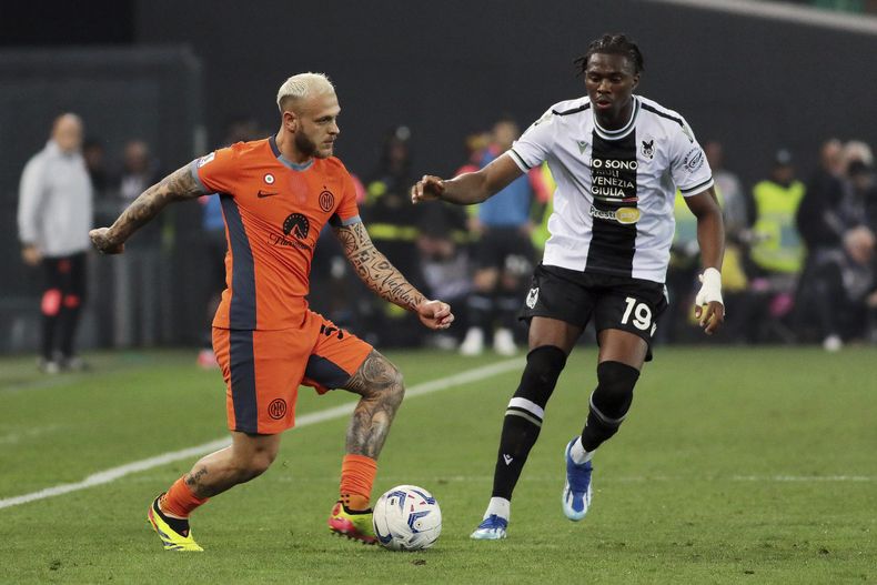 Federico Dimarco (izquierda) del Inter de Milán y Kingsley Ehizibue de Udinese pugnan por el balón en el partido de la Serie A de Italia, el lunes 8 de abril de 2024. (Andrea Bressanutti/LaPresse vía AP)