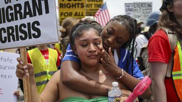 Daisy Morán, a la izquierda, y Constance Felton participan en una protesta contra las redadas del ICE y las detenciones para deportación, mientras la policía bloquea su marcha el sábado 14 de junio de 2025, en Chamblee Tucker Road, Atlanta. (Arvin Temkar/Atlanta Journal-Constitution vía AP)