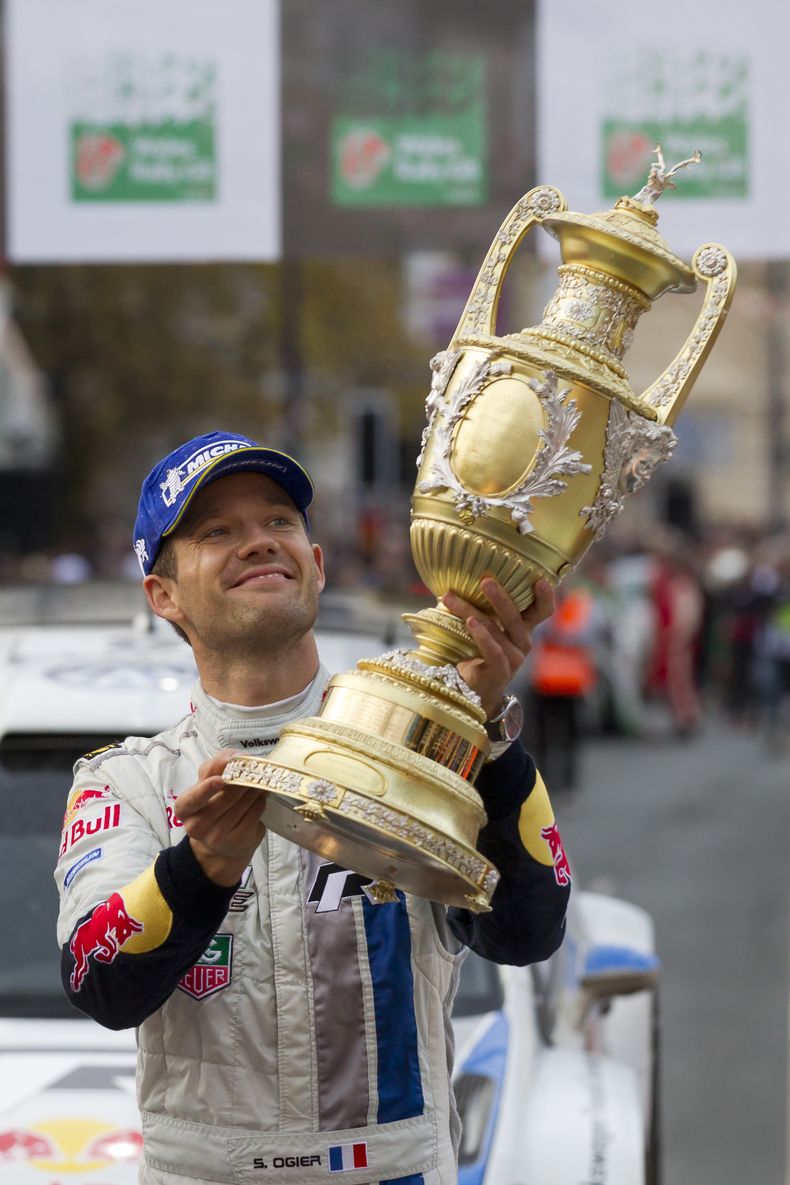 El franc&eacute;s Sebastien Ogier sostiene el trofeo que gan&oacute; por su victoria en el rally de Gales, &uacute;ltima prueba de la temporada, en Llahdudno, Gales, el 17 de noviembre del 2013 (AP Foto/Jon Super)