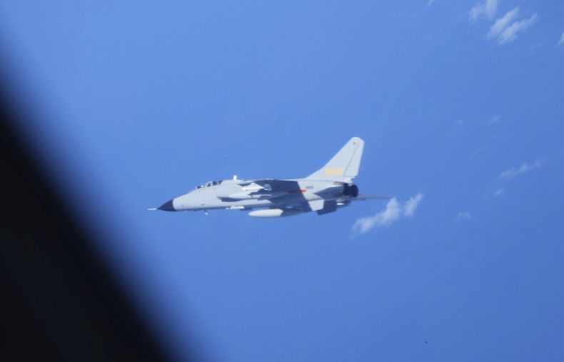 En esta fotografía proporcionada por el Ministerio de Defensa de Japón, se ve un cazabombardero chino JH-7, en el centro, cerca de un avión de inteligencia electrónica YS-11EB, visto parcialmente a la izquierda, de la Fuerza de Autodefensa Aérea de Japón sobre el Mar de China Oriental, el 9 de julio de 2025. (Ministerio de Defensa de Japón vía AP)