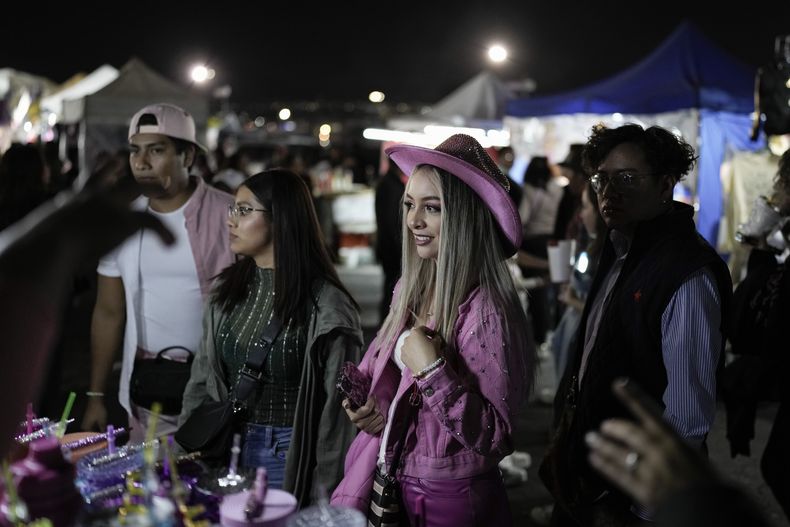 Una fan de Karol G compra mercancía previo a un concierto de su gira Mañana será bonito en el Estadio Azteca de la Ciudad de México el jueves 8 de febrero de 2024. (Foto AP/Eduardo Verdugo)