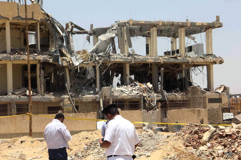 Polic&iacute;as investigan en el sitio donde ocurri&oacute; una explosion en el vecindario 6 de Octubre, un suburbio al sur de El Cairo, el s&aacute;bado 28 de junio de 2014. Una bomba casera colocada en la obra en construcci&oacute;n del gobierno y mat&o