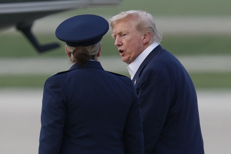 El presidente Donald Trump es escoltado por la subcomandante del Ala Aérea 89 de la Fuerza Aérea, Melissa Dombrock, mientras camina desde el Air Force One antes de abordar el Marine One, a su llegada a la Base Conjunta Andrews, Maryland, el 29 de julio de 2025. (AP Foto/Luis M. Álvarez)