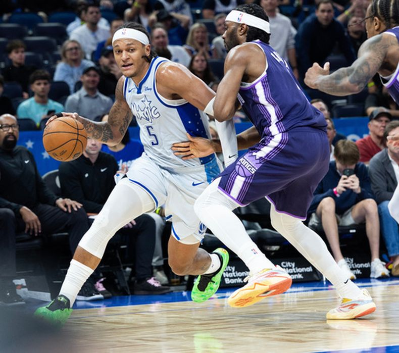 El italiano Paolo Banchero, del Magic de Orlando, elude a Precious Achiuwa, de los Kings de Sacramento, en el duelo del jueves 26 de marzo de 2026 (AP Foto/Willie J. Allen Jr.)
