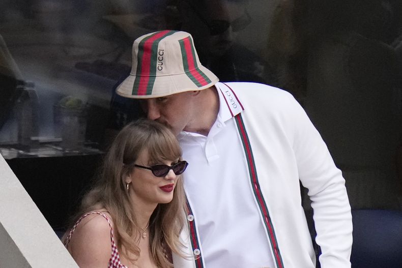 ARCHIVO - Taylor Swift recibe un beso del ala cerrada de los Chiefs de Kansas City, Travis Kelce, cuando llegan para ver el partido entre Jannik Sinner, de Italia, y Taylor Fritz, de los Estados Unidos, durante la final individual masculina del campeonato de tenis U.S. Open, el 8 de septiembre de 2024, en Nueva York. (Foto AP/Frank Franklin II, archivo)