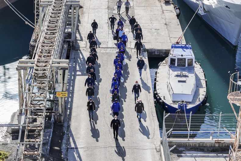 Una fotografía aérea tomada por un dron muestra a migrantes escoltados por la policía italiana en el puerto de Shengjin, Albania, el martes 28 de enero de 2025. (AP Foto/Vlasov Sulaj)