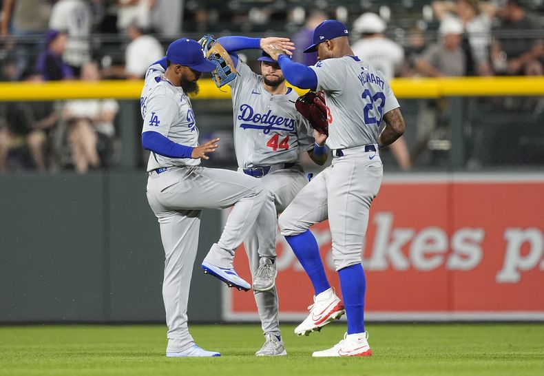 De izquierda a derecha, el jardinero izquierdo de los Dodgers de Los Ángeles, Teoscar Hernández, el jardinero central Andy Pages y el jardinero derecho Jason Heyward celebran tras vencer a los Rockies de Colorado el lunes 17 de junio de 2024, en Denver. (AP Foto/David Zalubowski)