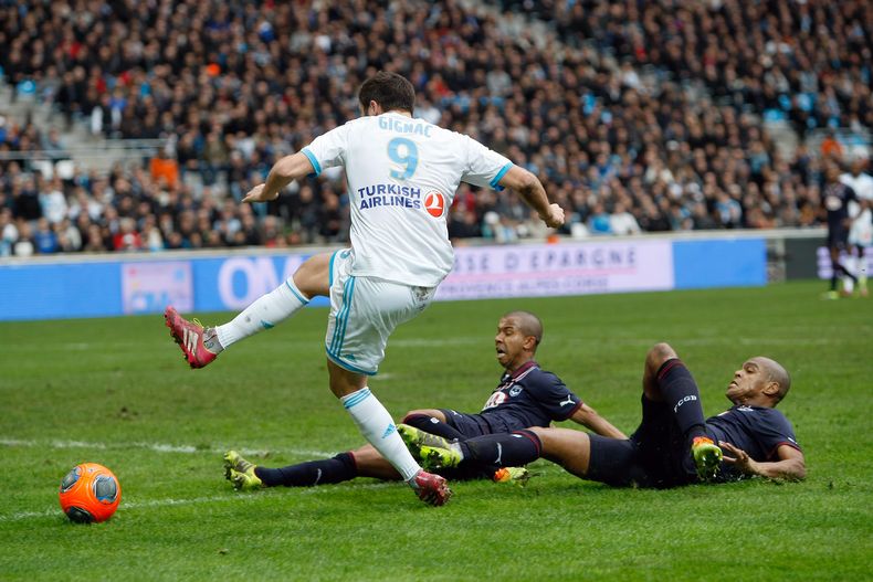 Andre/Pierre Gigna, de Marsella, de pie, ante dos jugadores de Bordeaux ca[idos, los brasile&ntilde;os Carlos Henrique dos Santos Souza y Ferreira Filho Mariano, durante un encuentro de la Liga Francesa en Marsella el domingo 22 de diciembre del 2013. (AP