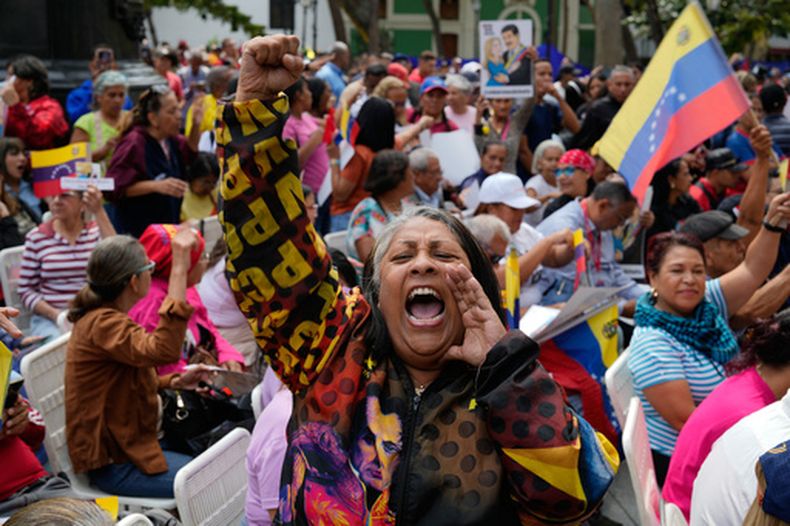 Una mujer grita durante un evento organizado por el gobierno para ver al expresidente Nicolás Maduro y a la exprimera dama Cilia Flores comparecer en un tribunal de Nueva York a través de una pantalla, el jueves 26 de marzo de 2026, en Caracas, Venezuela. (AP Foto/Ariana Cubillos)