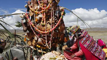americateve | Una ind&iacute;genaa aymara deja una ofrenda de alimentos en la tumba de de un familiar en el D&iacute;a de Difuntos en Alaypata, Bolivia, 2 de noviembre de 2014. (AP Foto/Juan Karita)
