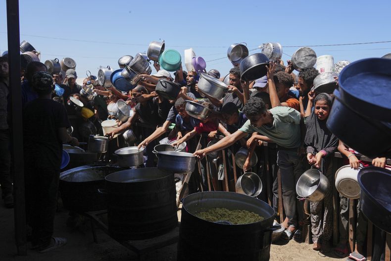 Palestinos luchan por obtener alimentos donados en una cocina comunitaria en Jan Yunis, al sur de la Franja de Gaza, el lunes 1 de septiembre de 2025. (AP Foto/Abdel Kareem Hana)