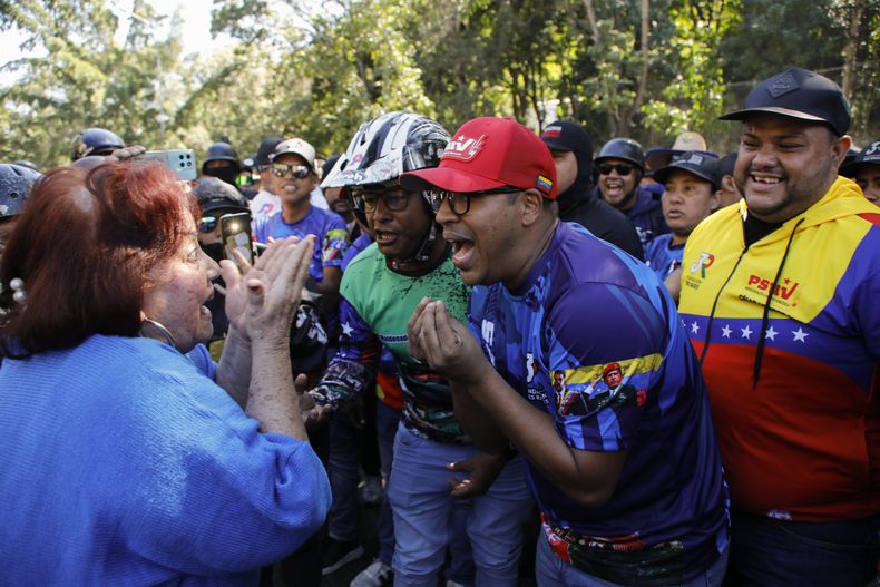 Seguidores del gobierno, a la derecha, se enfrentan a un opositor al presidente Nicolás Maduro en una manifestación convocada por la oposición un día antes de la toma de posesión presidencial, en Caracas, Venezuela, el jueves 9 de enero de 2025. (AP Foto/Cristian Hernández)
