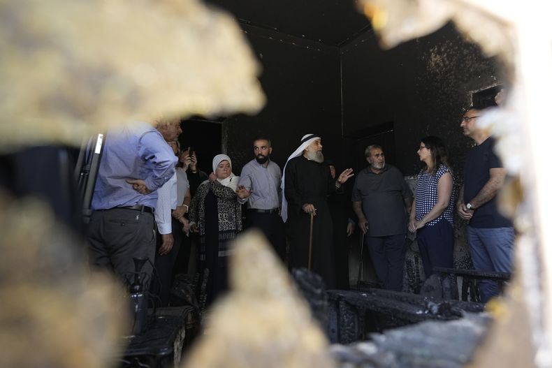 Varios palestinos hablan con una delegación internacional que recorre la ciudad cisjordana de Turmus Ayya, días después de un ataque de colonos judíos, el viernes 23 de junio de 2023. (AP Foto/Majdi Mohamed)