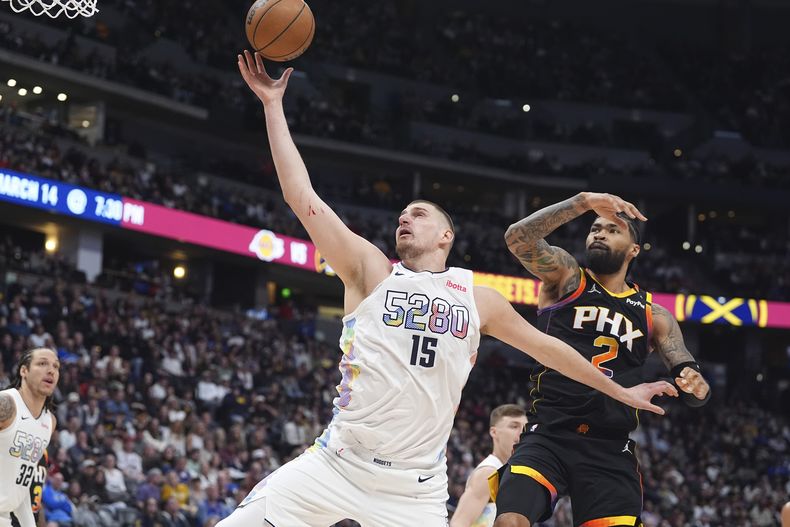 El serbio Nikola Jokic, pívot de los Nuggets de Denver, captura un rebote frente a Nick Richards, pívot de los Suns de Phoenix, en el duelo del vierne s7 de marzo de 2025 (AP Foto/David Zalubowski)