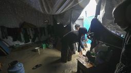 Manal Lubbad, de 49 años, madre de ocho hijos y desplazada desde Ciudad de Gaza, intenta limpiar su carpa inundada tras fuertes lluvias durante la noche en el campamento para refugiados en Deir al Balah, en el centro de la Franja de Gaza, el martes 31 de diciembre de 2024. (AP Foto/Abdel Kareem Hana)