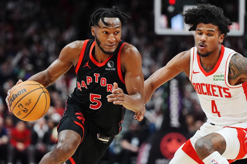Immanuel Quickley, de los Raptors de Toronto, dribla a Jalen Green, de los Rockets de Houston, en el encuentro del viernes 9 de febrero de 2204 (Frank Gunn/The Canadian Press via AP)